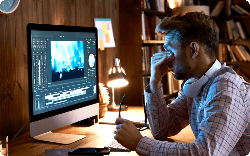 Man touching dry eyes in front of computer