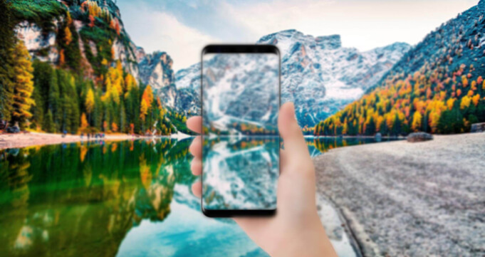 hand holding cell phone with clear view of the river and mountain
