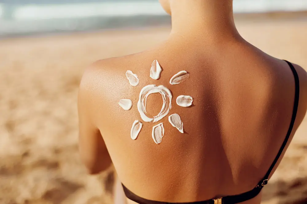 woman at beach with sunblock on her back