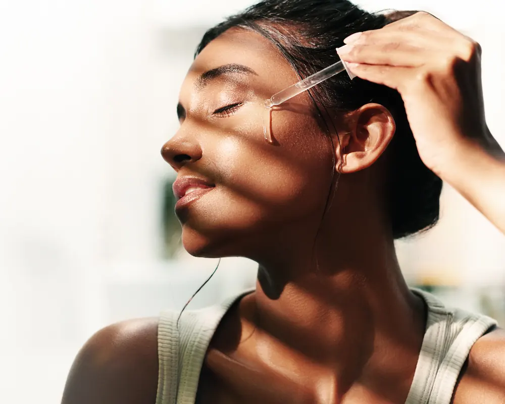 beautiful woman applying Vitamin C Serum to her face